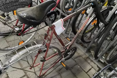 Fahrradleichen in der Radabstellanlage am Hauptbahnhof mit Hinweiszettel auf die Entfernung der Bahn.