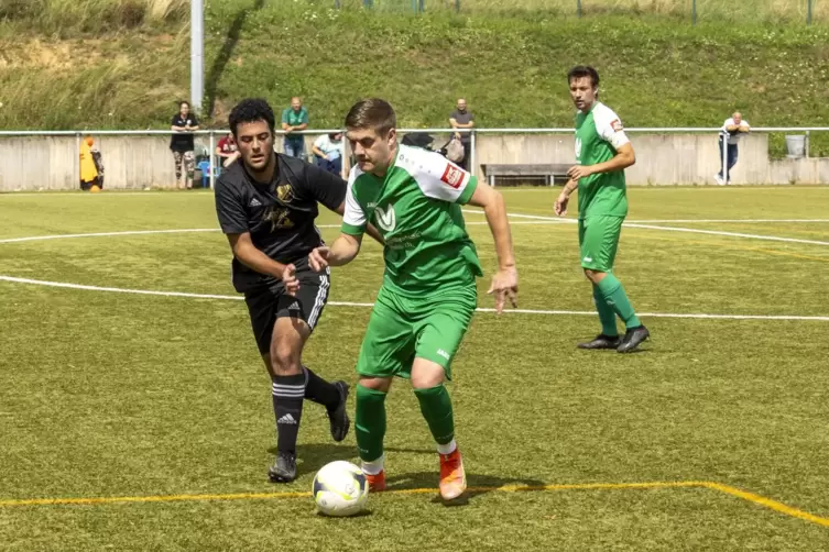  Okan Turan vom TuS Ilbesheim (links) versucht Arne Held von der TSG Kerzenheim den Ball abzuluchsen. 