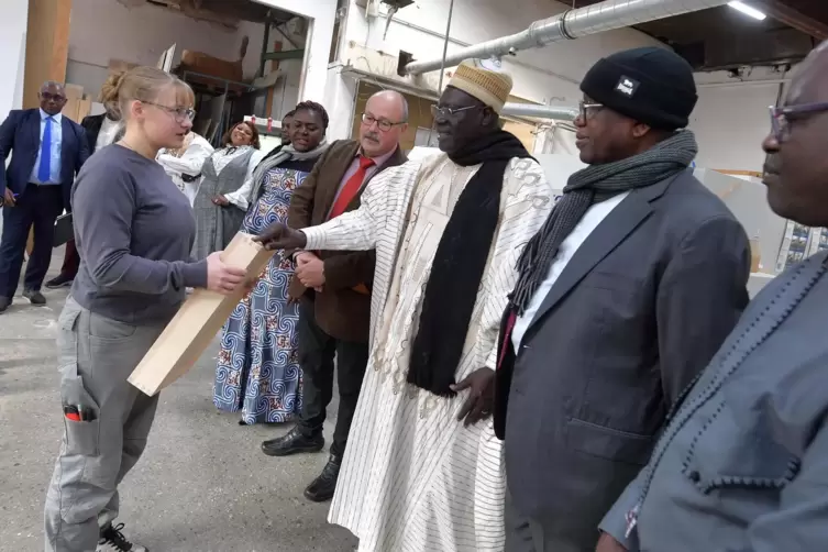 Minister Mounouna Foutsou (Zweiter von rechts) lässt sich von Gesellin Anna Fischer ihre Pflichtprüfungsarbeit bei der Gesellenp