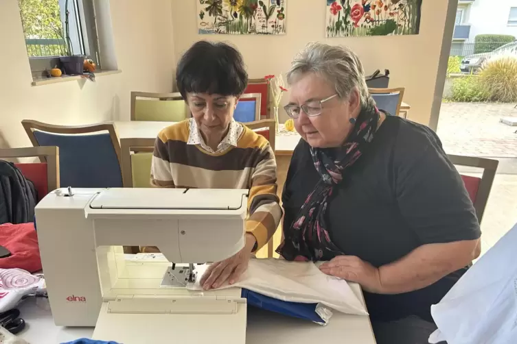 Bettina Krebs (rechts) unterstützt eine Teilnehmerin des Nähcafes bei ihrem ersten Projekt. 