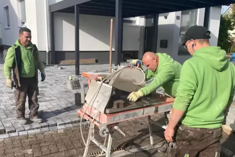 Muss jetzt jede Fahrt abrechnen: Rainer Elzer (links) verlegt mit seinen Mitarbeitern Pflastersteine auf einem Grundstück in Sch