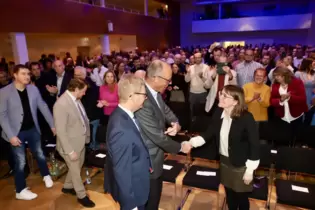 Friedrich Merz begrüßt Besucher per handschlag.