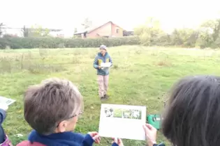 Christoph Kohler vom BUND spricht an einer Wiesenfläche im Osten des Friedhofs über dort vorkommende Pflanzen und Insekten.