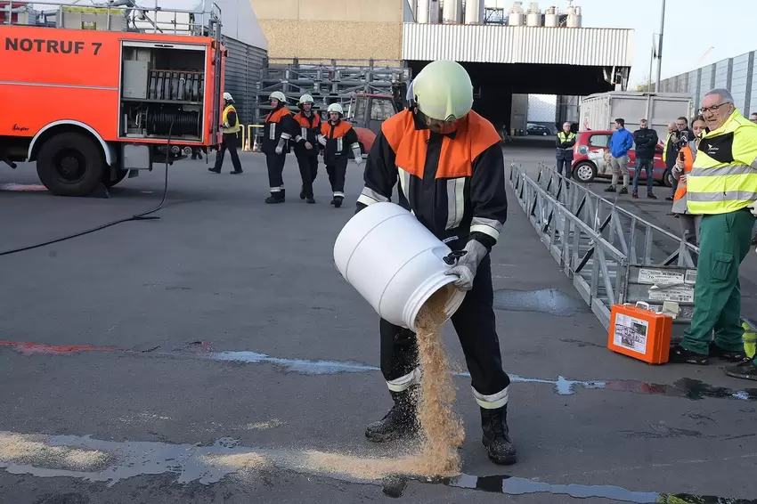 Ein Mitglied der Werkfeuerwehr sichert die ausgelaufene Batteriesäure.