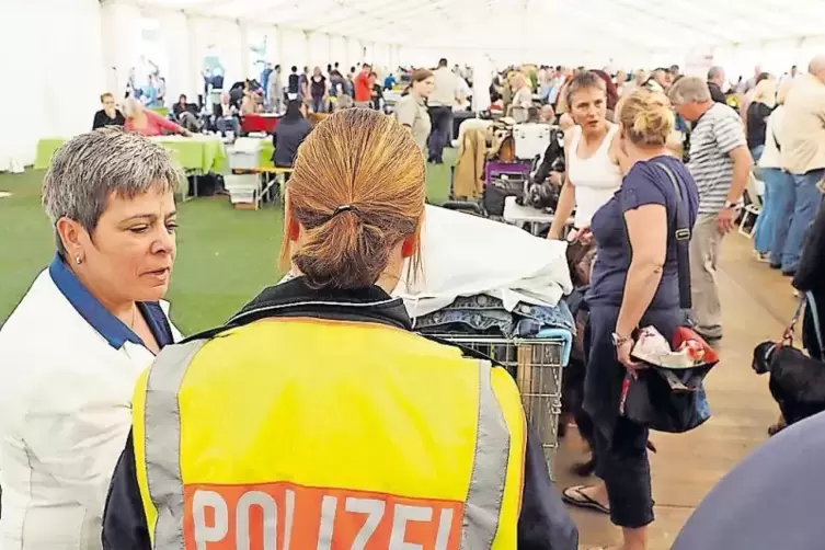 Eine Polizeibeamtin setzt freie Fluchtwege in den Zelten durch.