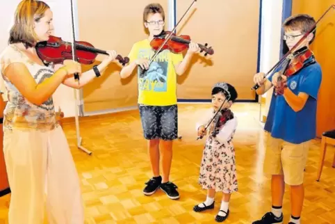 Heidi König, Suzuki-Lehrerin an der Musikschule Leiningerland, übt (von links) mit dem zwölfjährigen Florian Kalhofer, der dreij
