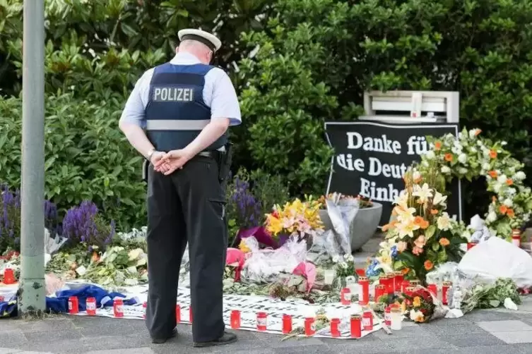 Arbeit und Anteilnahme: ein Polizist am Kanzlerbungalow.  Foto: dpa