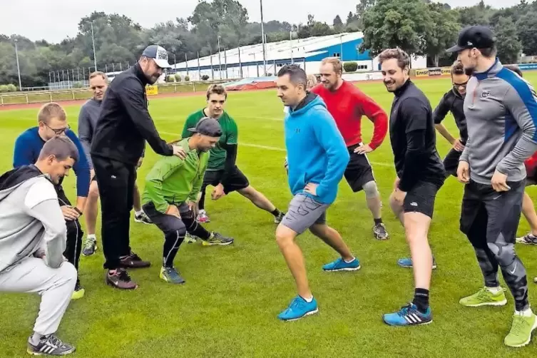 Auf geht’s, dehnen! Danach ließ EHC-Trainer Tomas Vodicka (Dritter von links, mit Kappe) seine Jungs im ersten Training viel lau