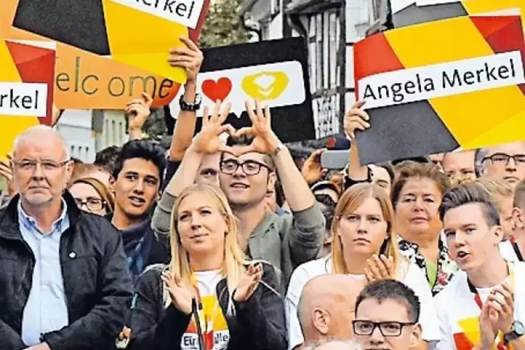 Auf dem Marktplatz erhält Merkel viel Zuspruch, muss aber auch mit einer Gruppe lautstarker Protestler zurechtkommen.