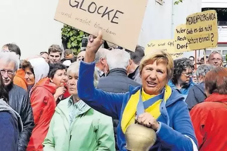 „Ein Glocke ist eine Glocke und macht bim-bam“, steht auf einem Plakat, das eine der Demonstrantinnen gegen die NPD-Kundgebung h