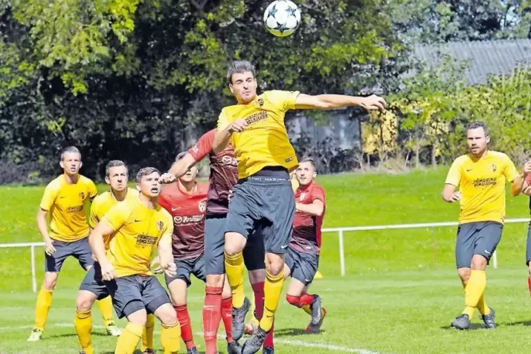 Der Knittelsheimer Carsten Meyer (gelbes Trikot) klärt per Kopf.