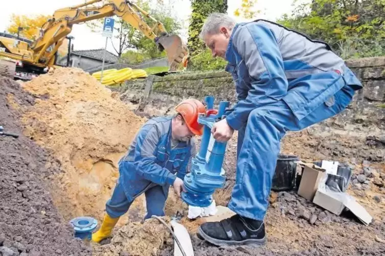 Jürgen Eisenhauer (links) und Michael Lang von den Stadtwerken reparieren in der Landeckstraße eine defekte Wasserleitung. In de