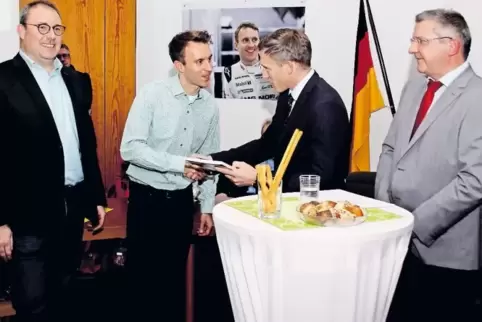 Bevor sich Weltmeister Timo Bernhard ins Gästebuch der Verbandsgemeinde eintrug, überreichte ihm Landrat Ralf Leßmeister das Jah