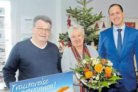 Über einen 10.000 Euro-Reisengutschein freuen sich Karin und Ludwig Stock, und mit ihnen Benjamin Baudisch von Sparda Südwest.