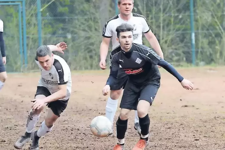 Kampf um den Ball: Münchweilers Daniel Hoffmann (links) verfolgt Hilsts Robin Gurschek, dahinter sieht Tobias Hoffmann zu.