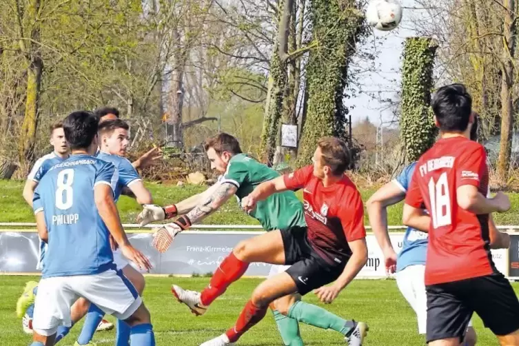 Berghausens Julian Ehrenberg (rotes Trikot) versucht einen Fallrückzieher, wird aber von Queichhambachs Torwart Daniel Brust ges