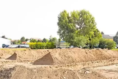 Im Hintergrund des Baugeländes an der Weinstraße sieht man links die Tankstelle sowie rechts die Grundschule und die Kita.