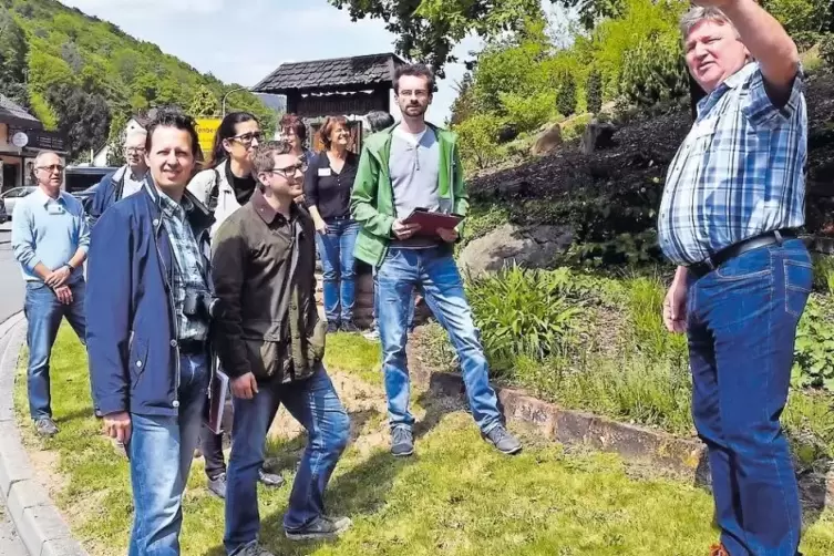 Ortsbürgermeister Reiner Koch (rechts) zeigt der Jury den Lindenberger Ortseingang.