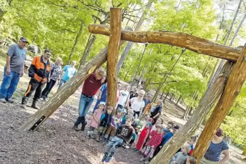 Förster Klaus Platz (rotes T-Shirt) erläutert den Kindern des Waldkindergartens, was der Waldspielplatz „Fuchsbau“ für Besonderh