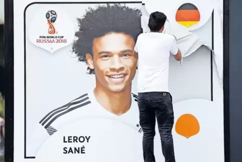 An ihm scheiden sich die Geister: Ein Mitarbeiter zieht eine Folie mit dem Porträt des deutschen Nationalspielers Leroy Sané von