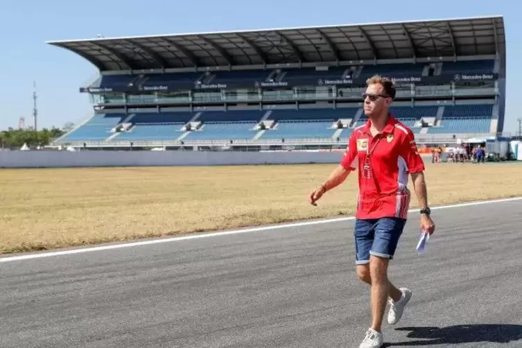 Ferrari-Pilot Sebastian Vettel geht über die Rennstrecke des Hockenheimrings. Foto: dpa