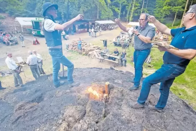 Darauf einen Schnaps: Nach der Meilertaufe begießen (von links) Köhler Hans Wagner, Meilerpate Peter Schmidt und Gehilfe Andy Ni