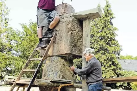 Otmar Schrick (oben) und Günter Müller legen sich beim Aufstellen des Steinemanns ordentlich ins Zeug.