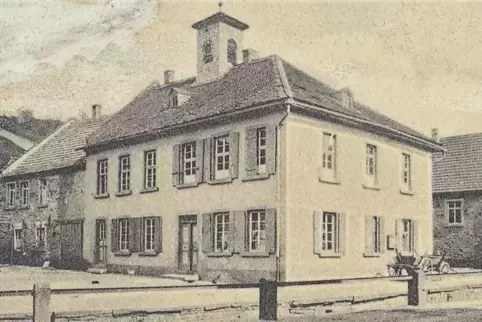 Aufnahme von 1921: das alte Schulhaus mit Glockentürmchen, an dessen Stelle heute das Bürgerhaus steht. Das Nachbargebäude (link