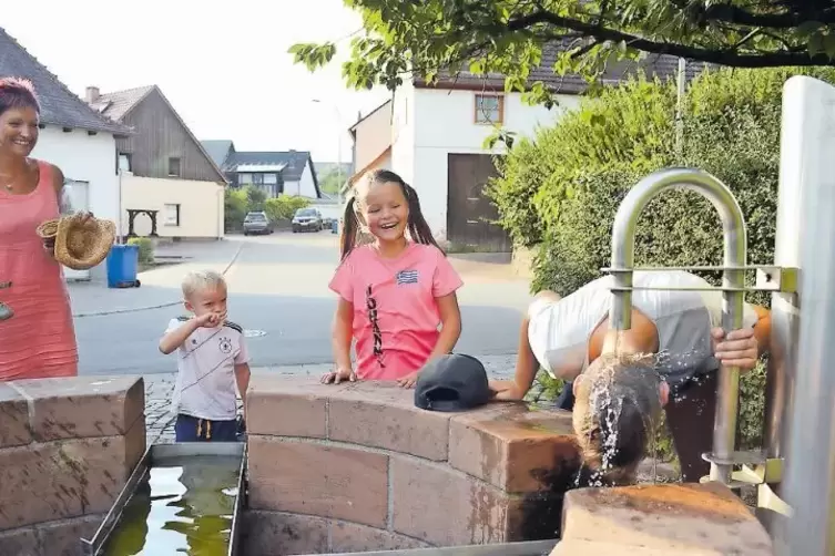 Abkühlung am Dorfbrunnen: Trotz der Hitze hatten sich viele Hermersberger zum RHEINPFALZ-Dorfspaziergang zusammengefunden.