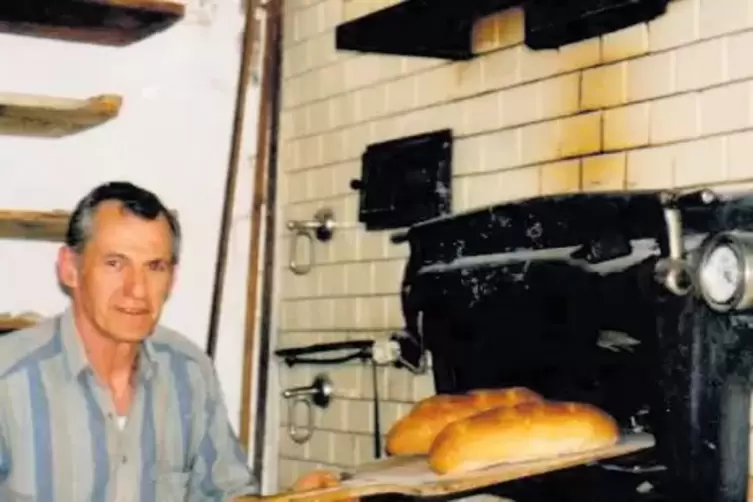 Wolfgang Steinhauser, in der dritten Generation Bäcker, schiebt Brot in den alten Backofen. Heute beherbergt der Laden eine Bäck