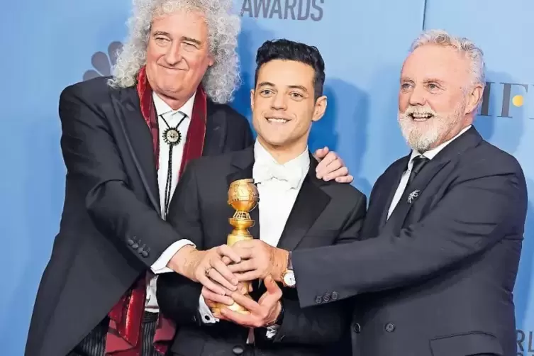 Die Musiker Brian May (links) und Roger Taylor (rechts) von Queen freuen sich mit Rami Malek, der für seine Darstellung von Quee