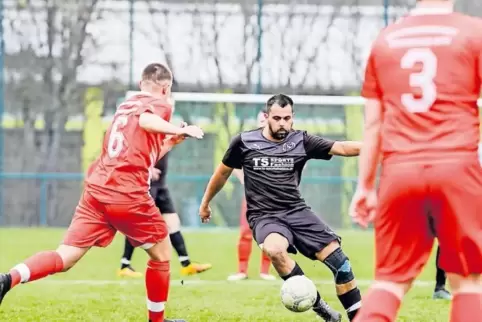 Schwarz gegen Rot: Florian Frohnheiser vom SV Mölschbach (Mitte) wird vom Spieler der SG Hochspeyer, Florian Gündel (links), bed