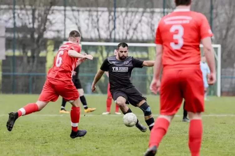 Schwarz gegen Rot: Florian Frohnheiser vom SV Mölschbach (Mitte) wird vom Spieler der SG Hochspeyer, Florian Gündel (links), bed