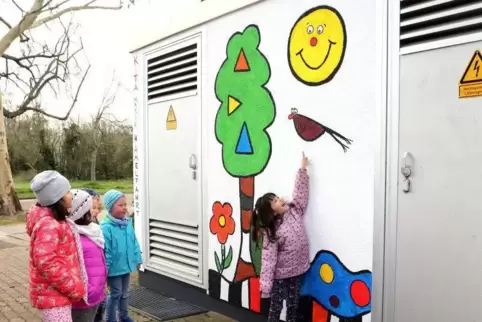 Da lacht nicht nur die Sonne: Die Kita-Kinder zeigen ihre Werke am Queichheimer Trafohäuschen.  Foto: Iversen