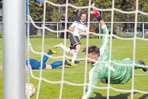 Alexander Wiemers trifft zum 2:0 für Edesheim. Haßlochs Fabian Theel kommt nicht mehr an den Ball.