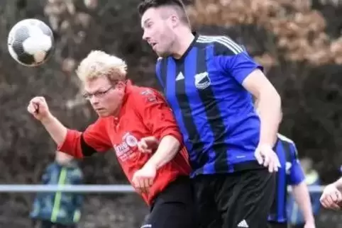 Mit seinem Team obenauf: Nils Klinck (TuS Bedesbach-Patersbach II, blaues Trikot), der in dieser Szene das Kopfballduell gegen N