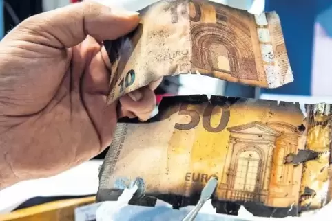 Ein Experte für beschädigtes Bargeld zeigt im Mainzer Nationalen Analysezentrum der Bundesbank eine 10-Euro- sowie eine 50-Euro-