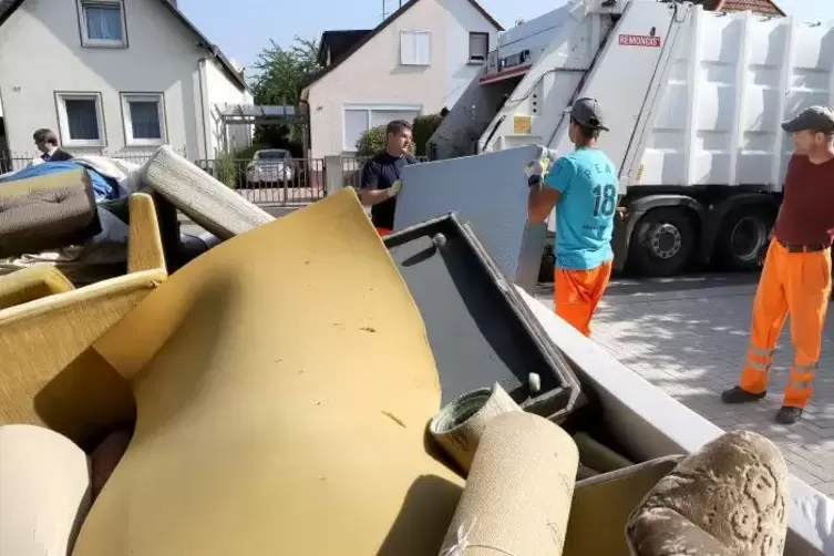 Sascha Klein, Damian Juraszek und Jürgen Frech von Remondis verladen in Queichheim Sperrmüll.  Foto: Iversen