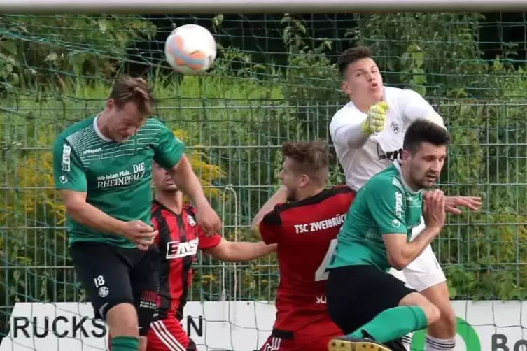 Strafraum-Getümmel: TSC-Torwart Merlin Schäfer behauptet sich per Faust gegen die VBler (in Grün) Patric Kuntz (rechts) und Luka