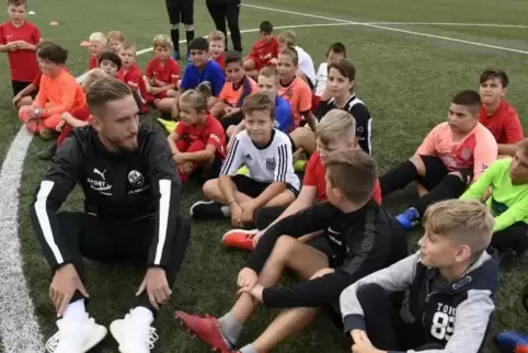 Ganz schön neugierig, die Kleinen: Robin Scheu vom SV Sandhausen beantwortet im Mittelkreis die Fragen der Nachwuchskicker des A