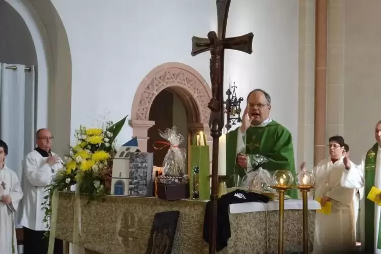 Umgeben von Abschiedsgeschenken: Pfarrer Joachim Voss beim feierlichen Segen.