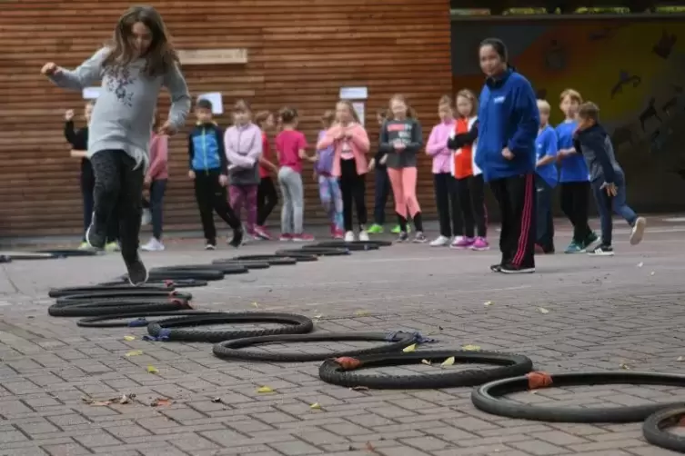 Wechselnd auf einem Bein durch die Fahrradreifen: Eine der Aufgaben beim Kinder-Leichtathletik-Cup.