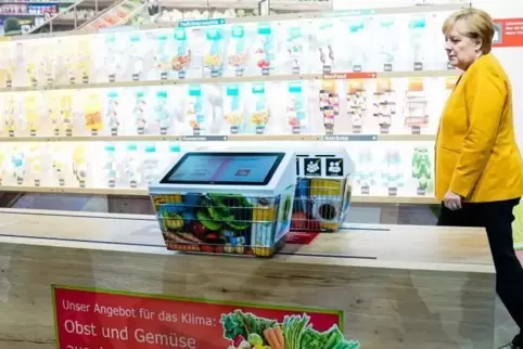 Angela Merkel bei einer Führung zur Eröffnung der Klima-Arena in einem Supermarkt-Modell.