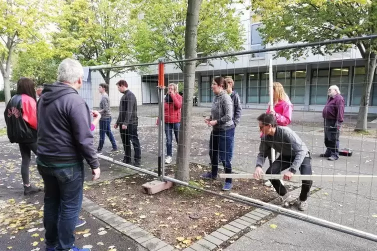 Zuerst errichten Lehrer und Schüler den Bauzaun.