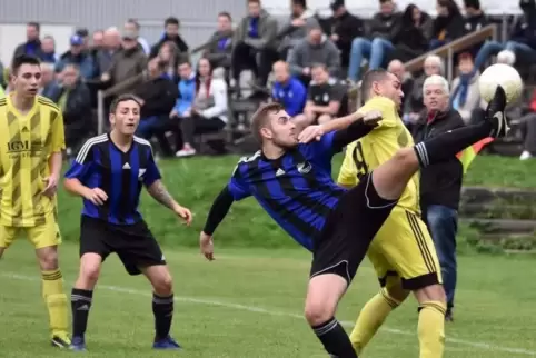 Hoch das Bein: TuS-Akteur Marius Hebel (blaues Trikot) ist vor Einöllens Spielertrainer Christopher Dispot am Ball. Kevin Brill 