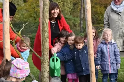 Kinder vollenden die Pflanzung symbolisch mit ausgiebigem Angießen.